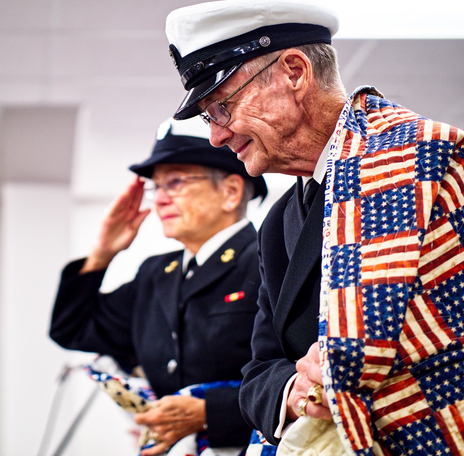 Barbara Melott salutes as Doc Melott grasps his newly-received quilt. The couple, both navy veterans of Vietnam, were touched and grateful for the gesture of support given to them Friday at the Quilts of Valor ceremony in Quitman. [view more veteran appreciation]